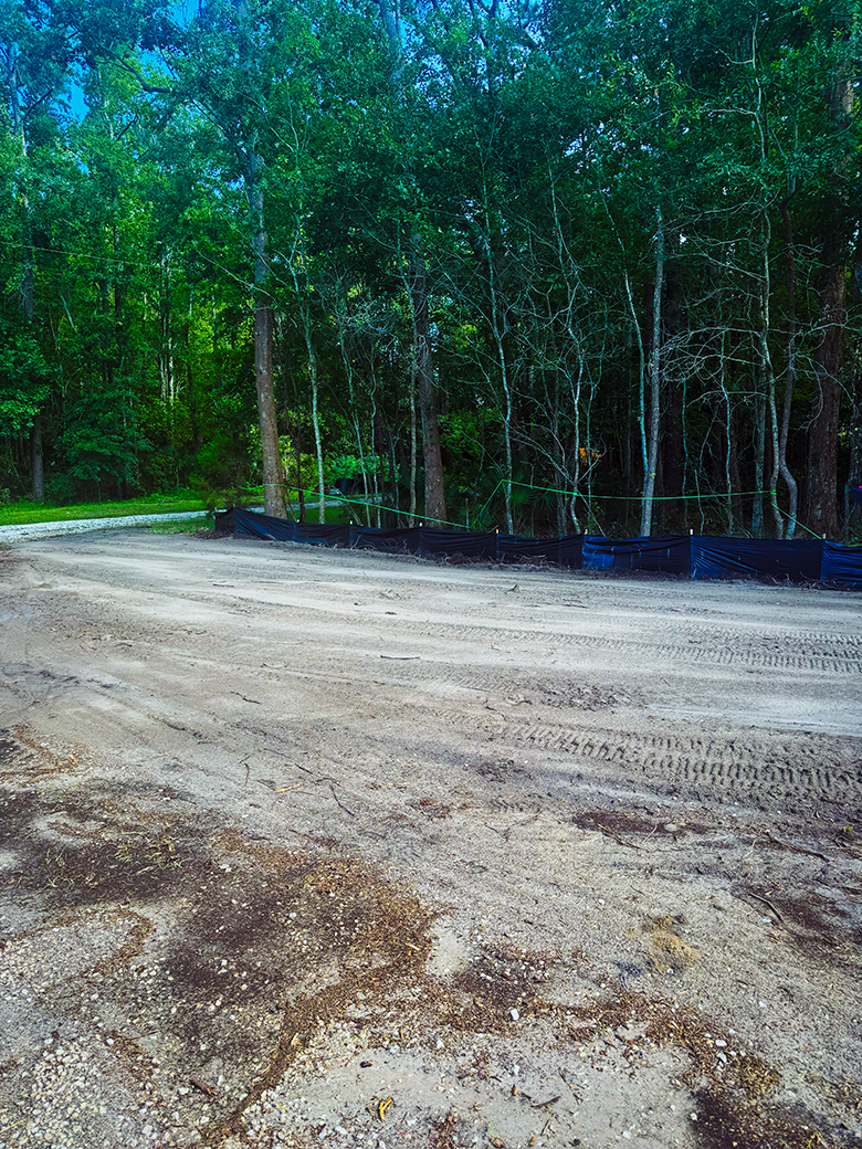 Graded access area beside a wooded construction site